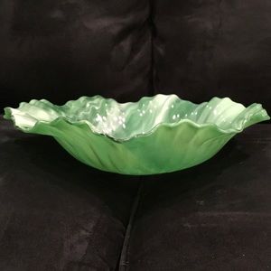 Bowl is green glass Ruffle edge. Signed